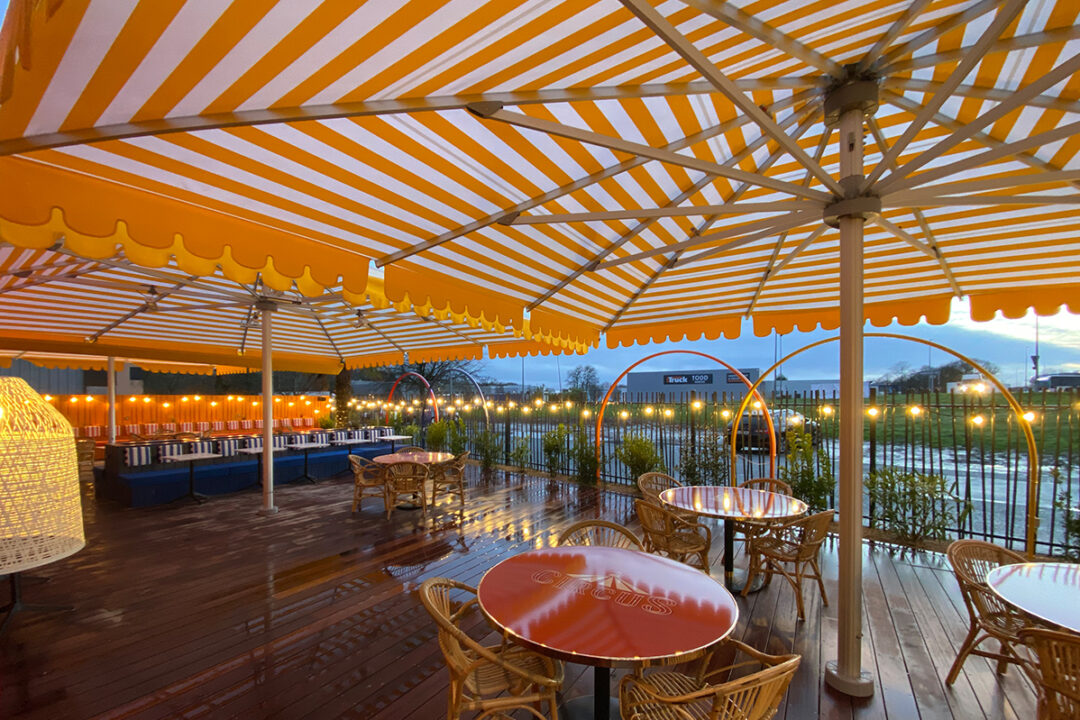 3 parasols géants Royal de 7x7 m et 6x6 m avec une toile rayée Jaune/Blanc pour donner le style cirque installés au restaurant Circus à Sainte-Luce-sur-Loire (44) par Espacio