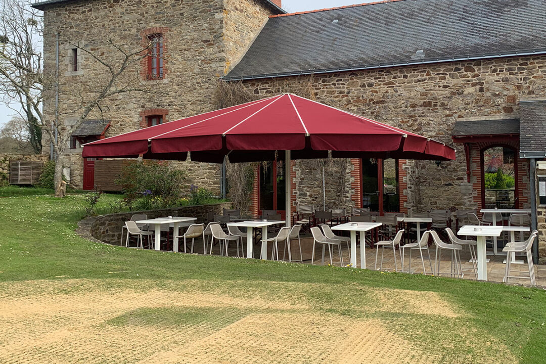 Un parasol géant Royal de 6x7 m avec une toile couleur Burgundy installé au Domaine de la Bretesche à Missillac (44) par Espacio