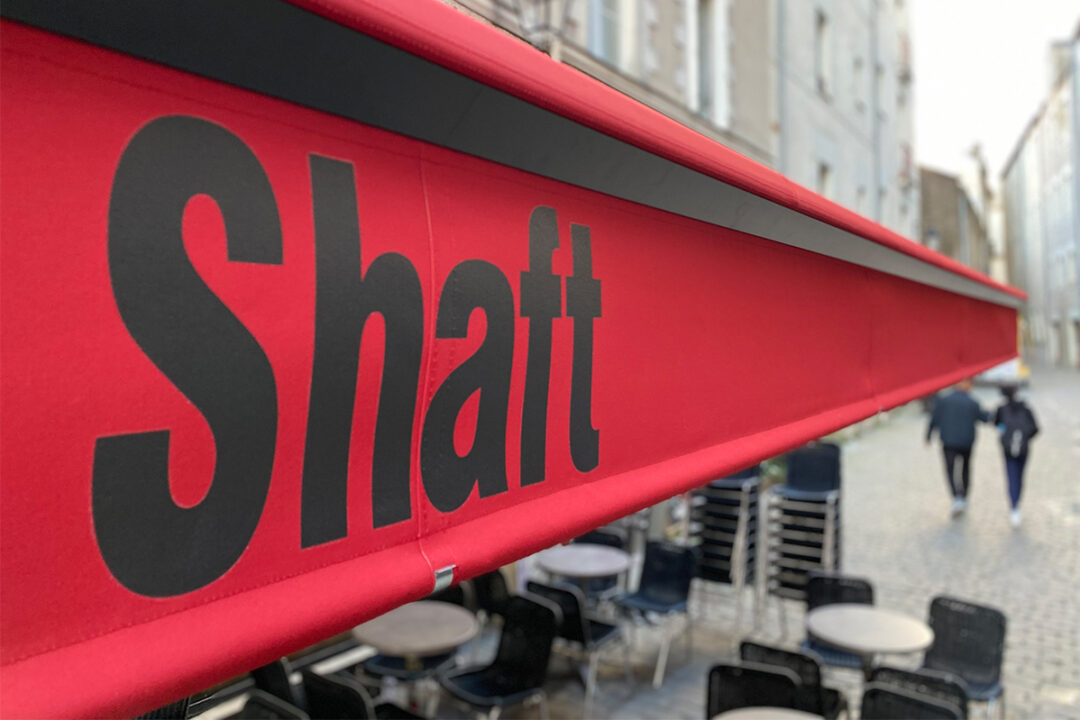 Store Banne Madrid de 9,2 mètres avec une toile coloris rouge installé au bar SHAFT à Nantes (44) par ESPACIO