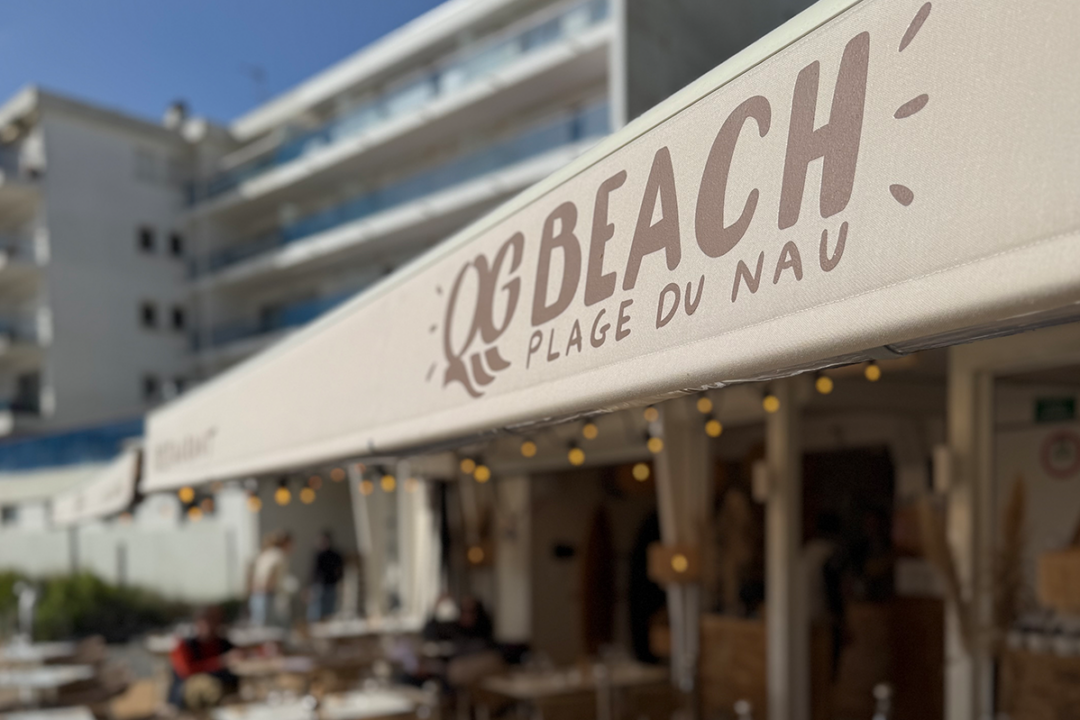 Ré-entoilage store banne et installation d'un lambrequin peint et guirlande LED au restaurant/bar QG Beach au Pouliguen (44) par ESPACIO.